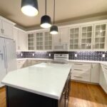 White shaker cabinets, navy island and quartz countertops in a Cary, NC kitchen remodel.