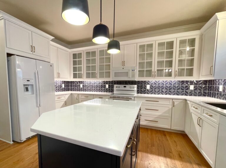 White shaker cabinets, navy island and quartz countertops in a Cary, NC kitchen remodel.